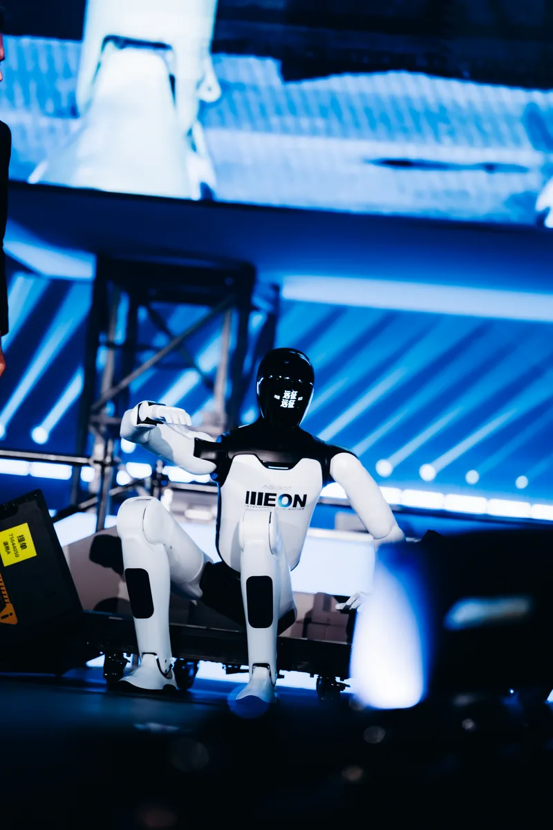AGIBOT A3 robot in a kneeling dance pose on stage at the LoveTomorrow event