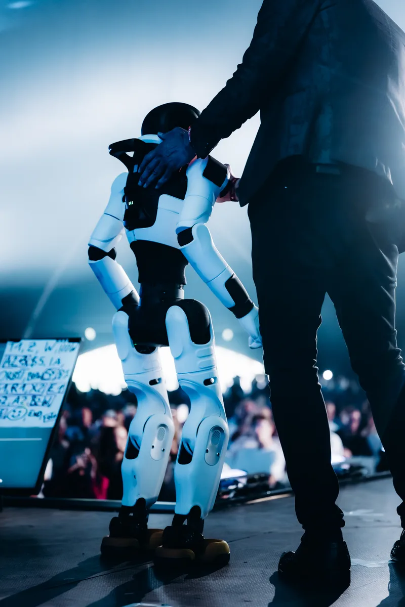 AGIBOT X2 robot being guided on stage at the LoveTomorrow event