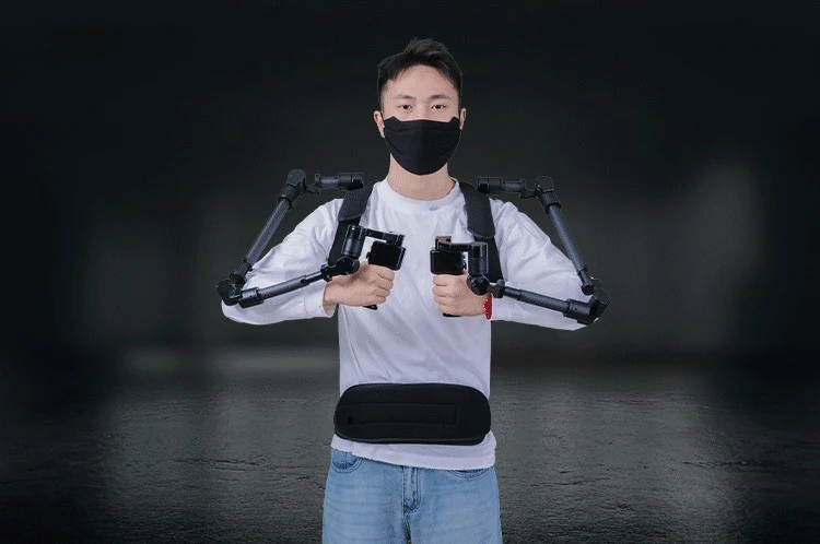A person wearing the Foxtech ExoArm-7 exoskeleton leader arm, gripping its handles